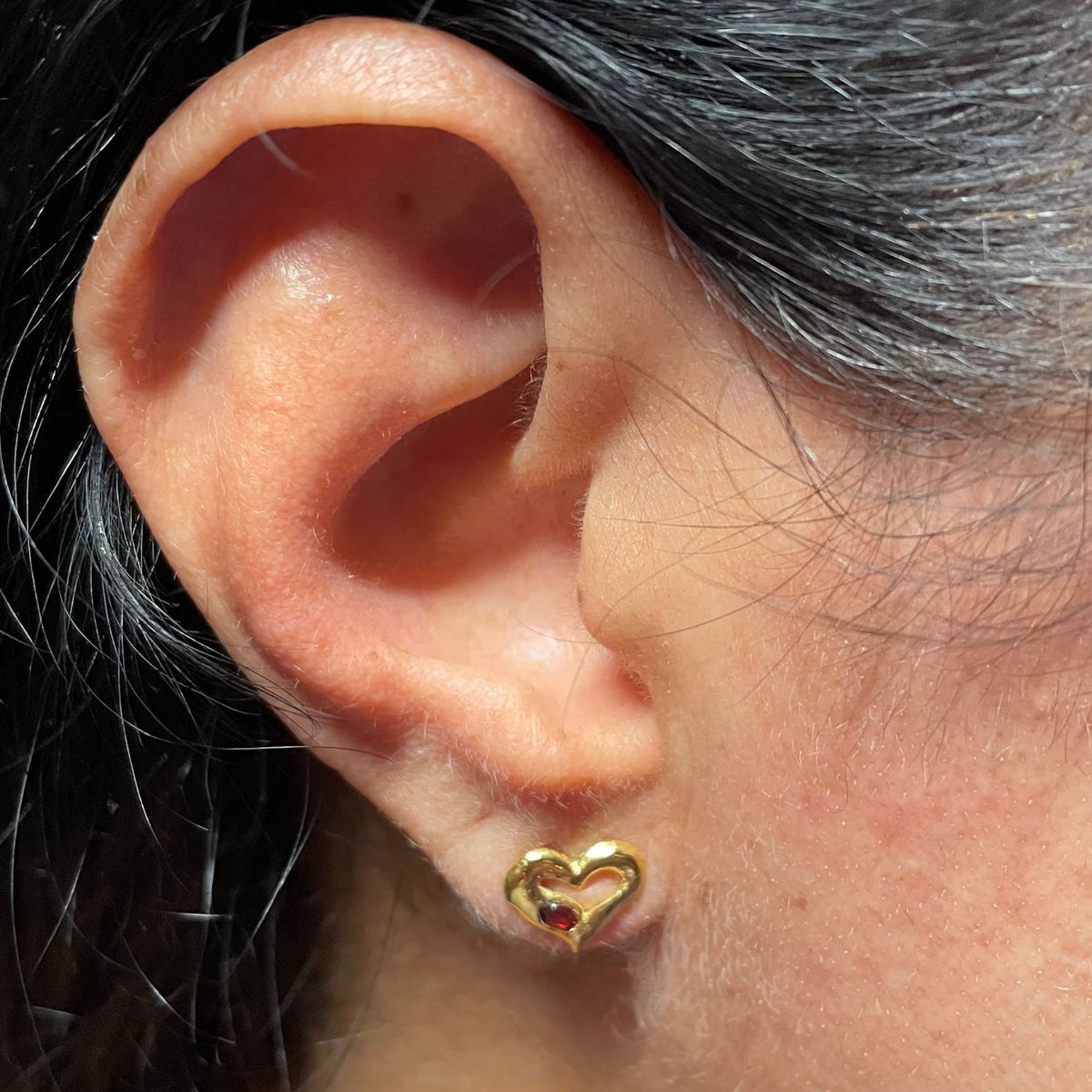 Gold garnet heart stud on ear by Amy Delson