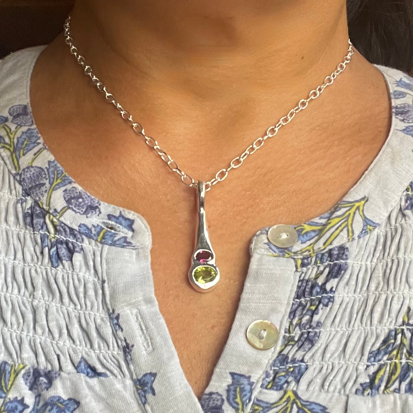 Amy Delson Peridot Garnet Silver Pendant necklace shown on neck
