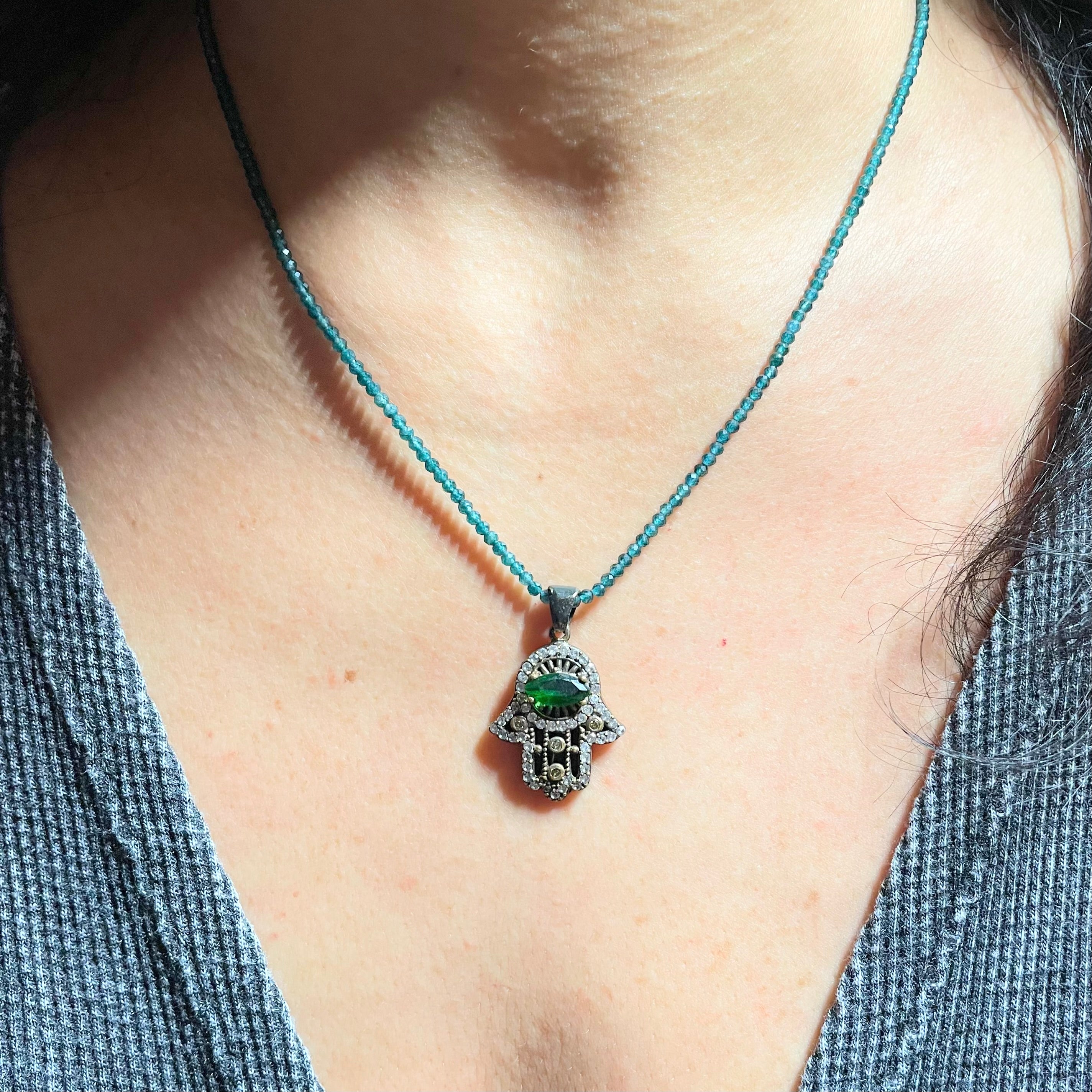 Green hamsa necklace shown on model