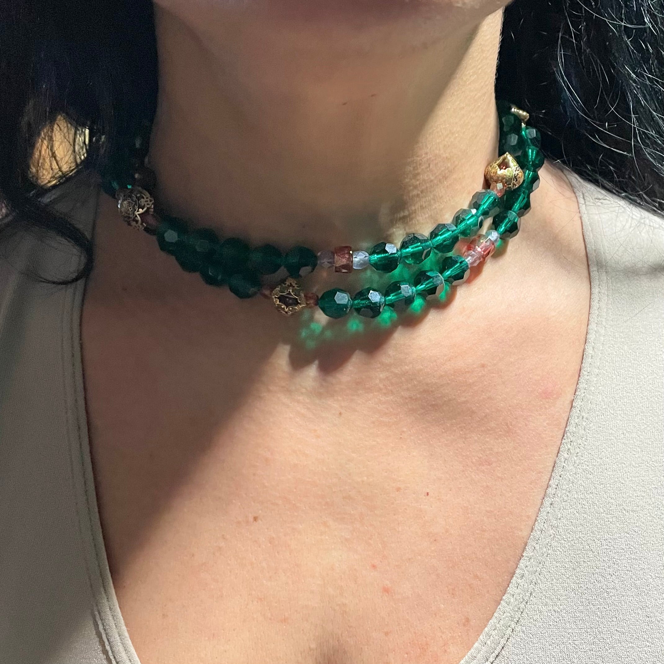 Green necklace shown doubled on neck