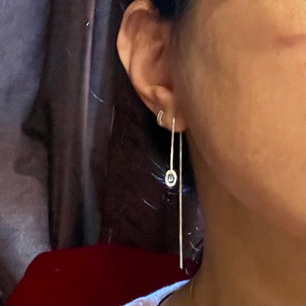 Amy Delson wearing her silver blue topaz threader earring