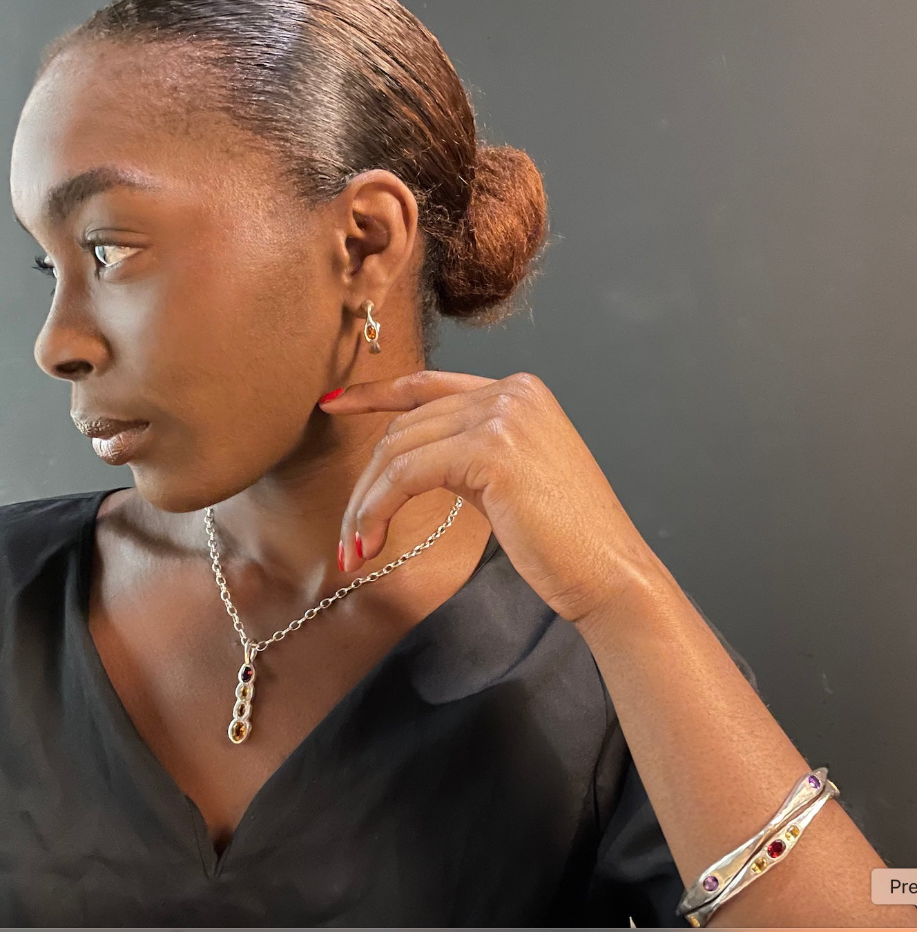 Model wears Amy Delson Jewelry hoop earrings, necklace and bangles in sterling silver and gemstones