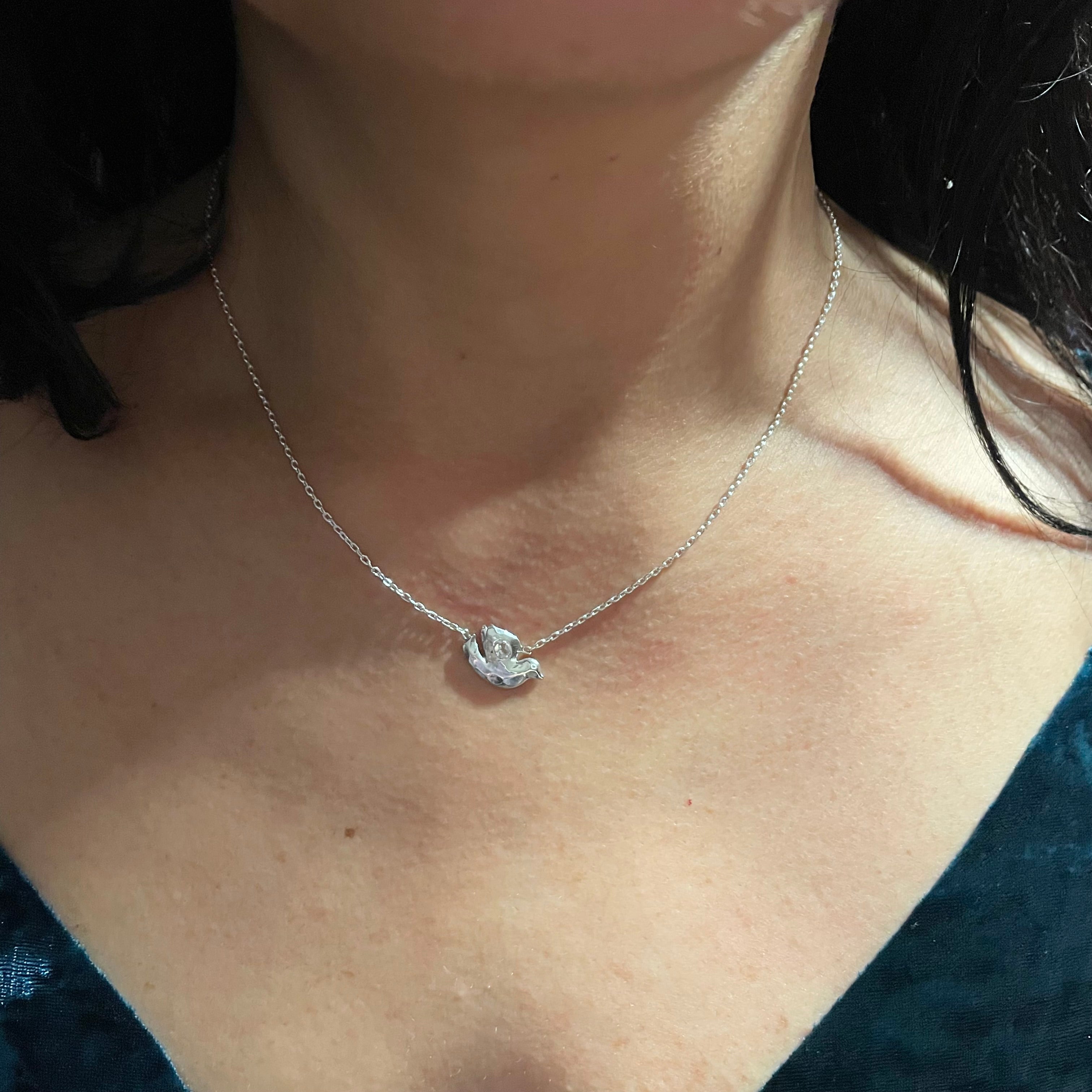 On neck: Sterling Silver Dove necklace with White Topaz by Amy Delson