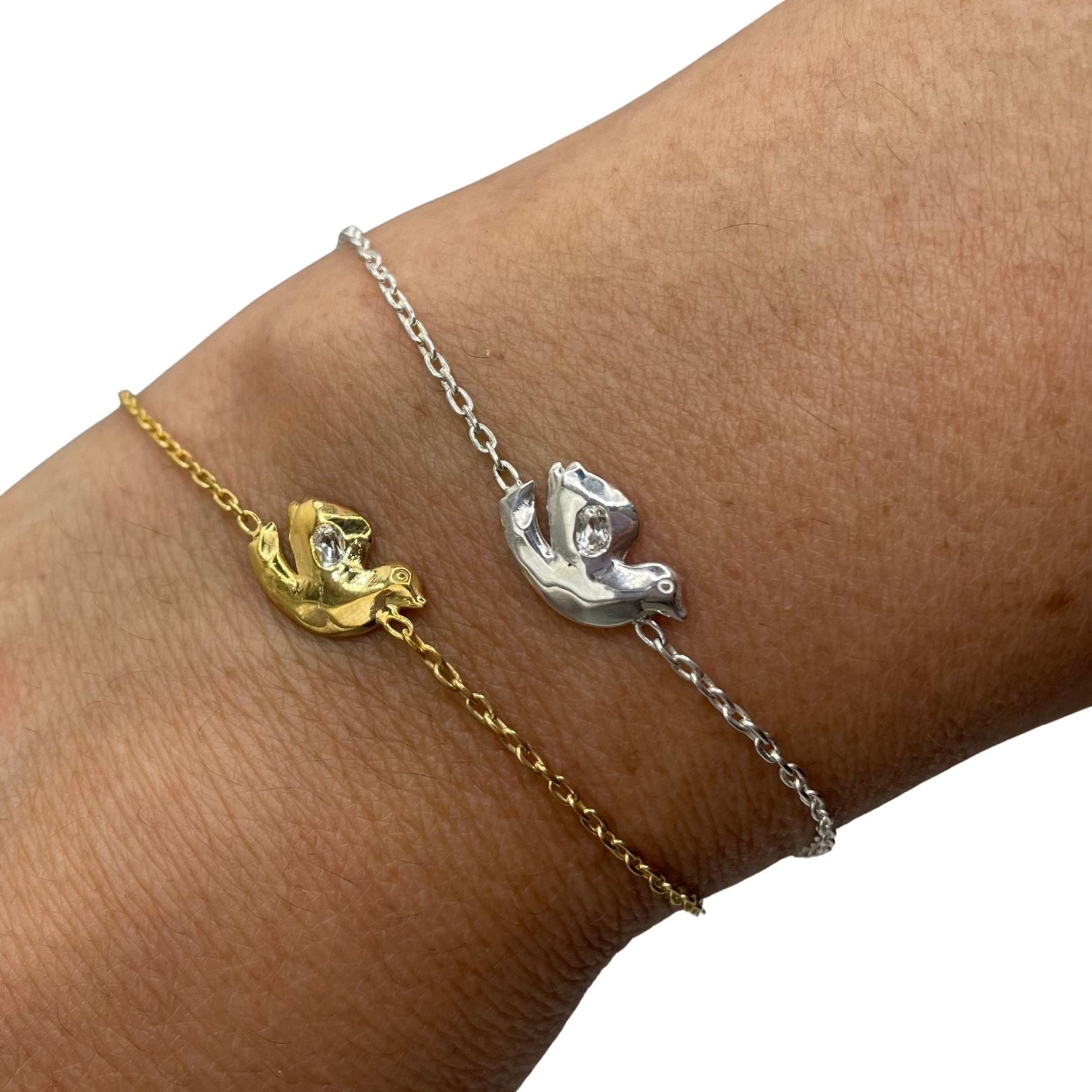 Shown on wrist: Sterling Silver and 18k gold vermeil with white topaz dove bracelets by Amy Delson