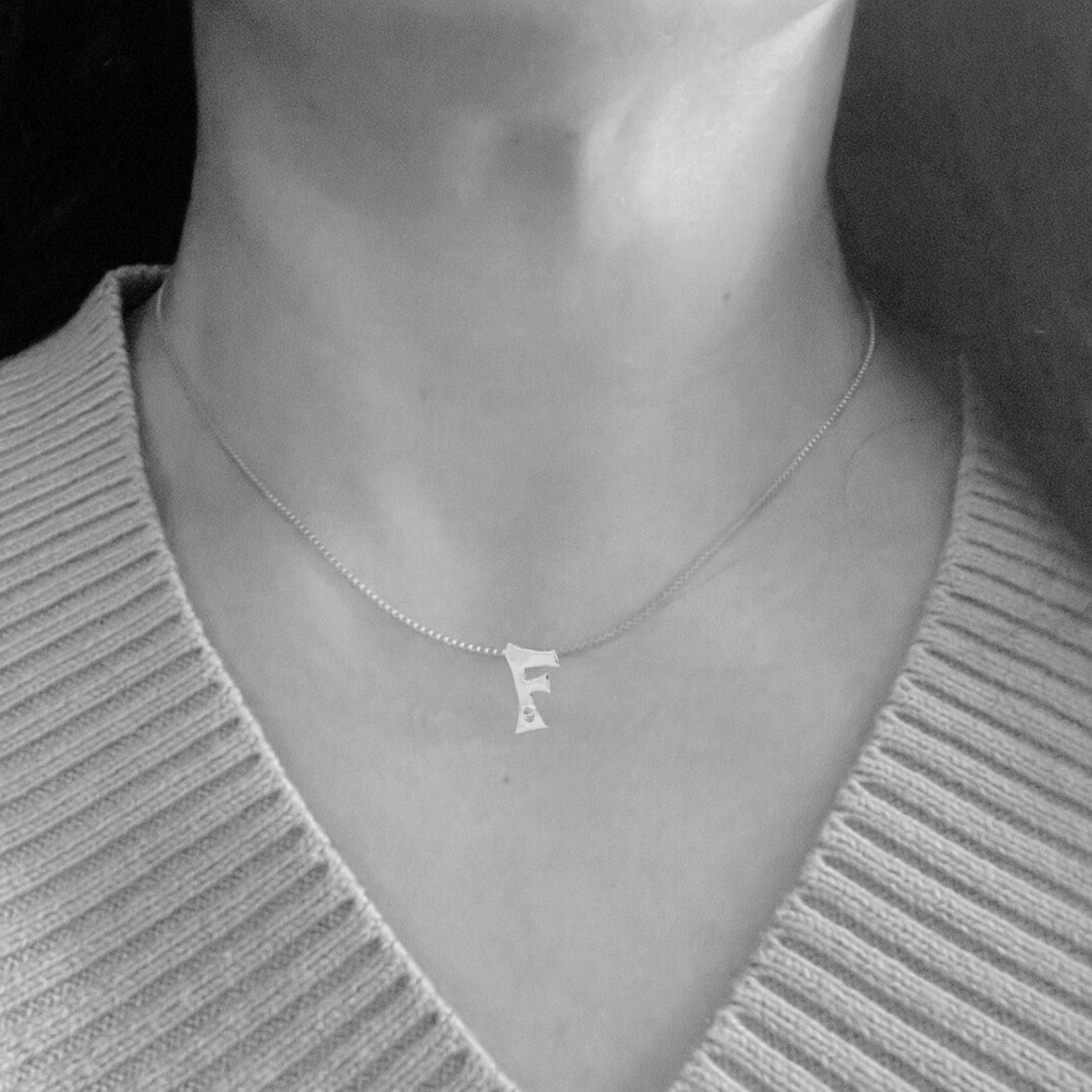 model wearing white gold with lab diamond letter F necklace by Amy Delson