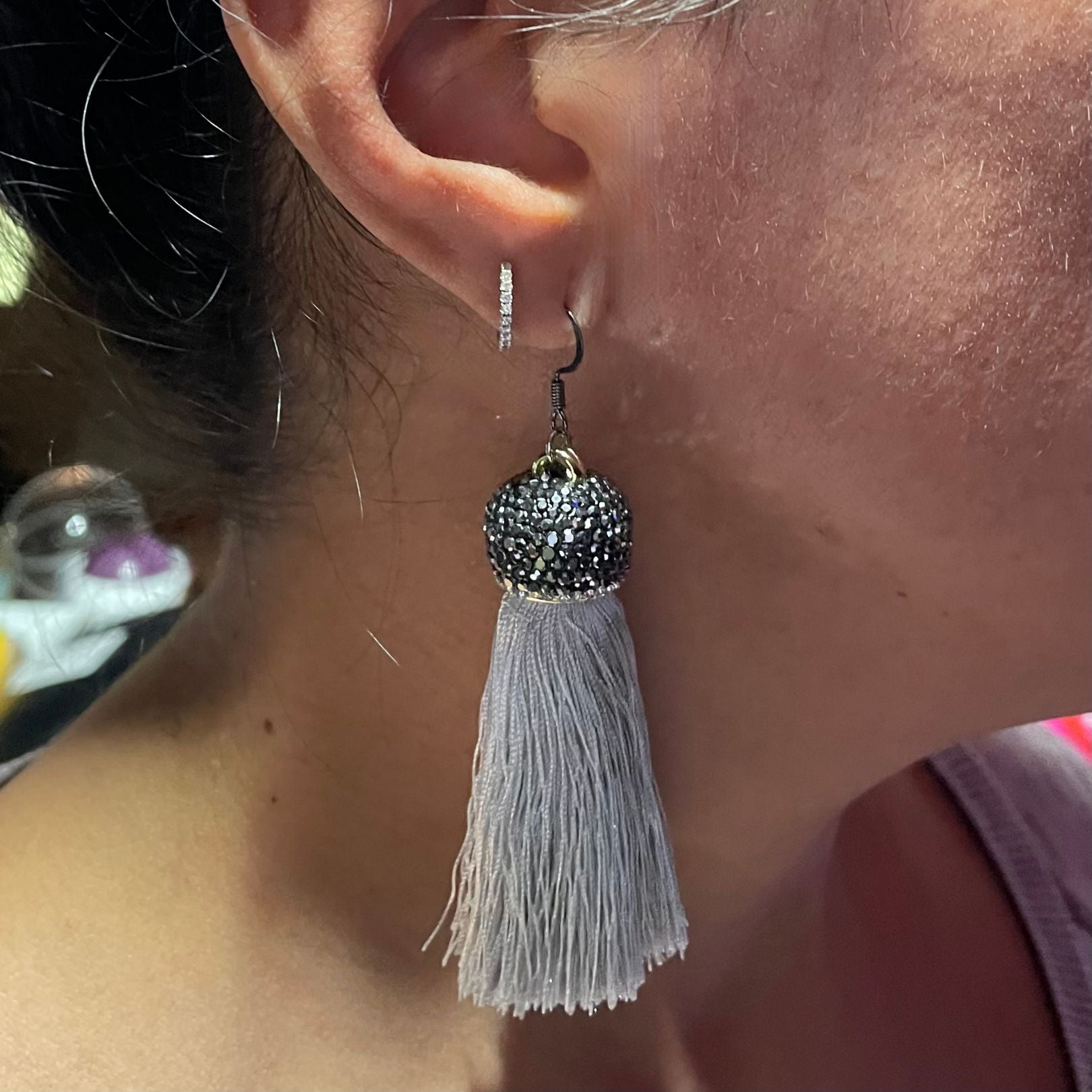 Shown worn on the ear: Amy Delson silver tassel earrings