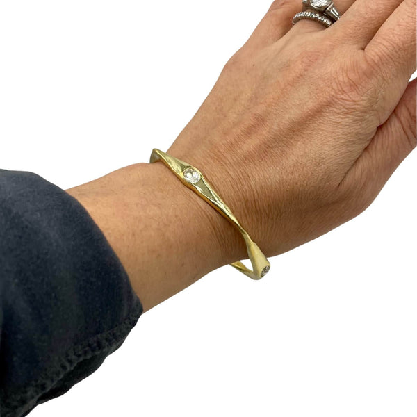 Amy Delson white Topaz gold bangle on wrist