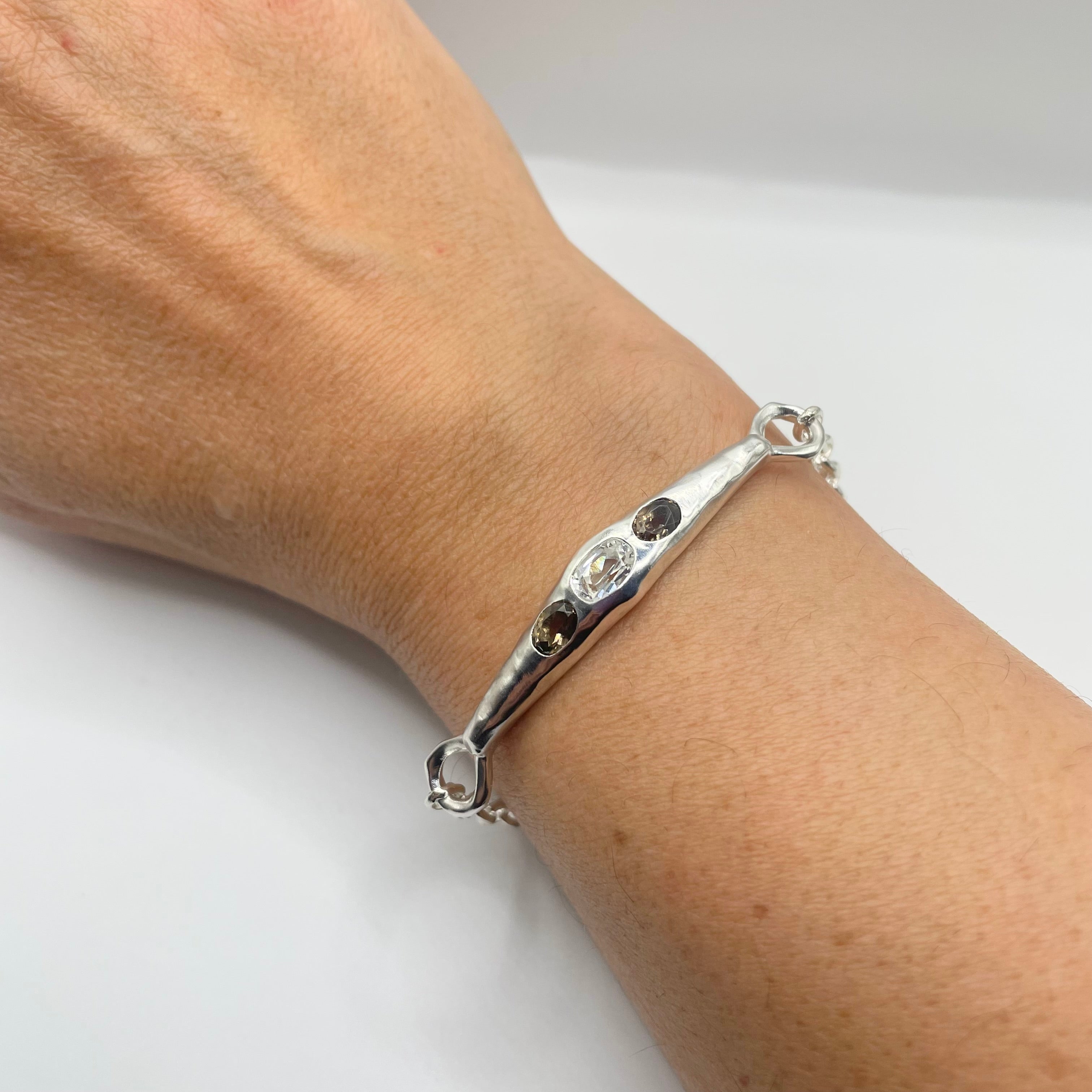 model wearing sterling silver white topaz, smoky quartz bracelet by Amy Delson