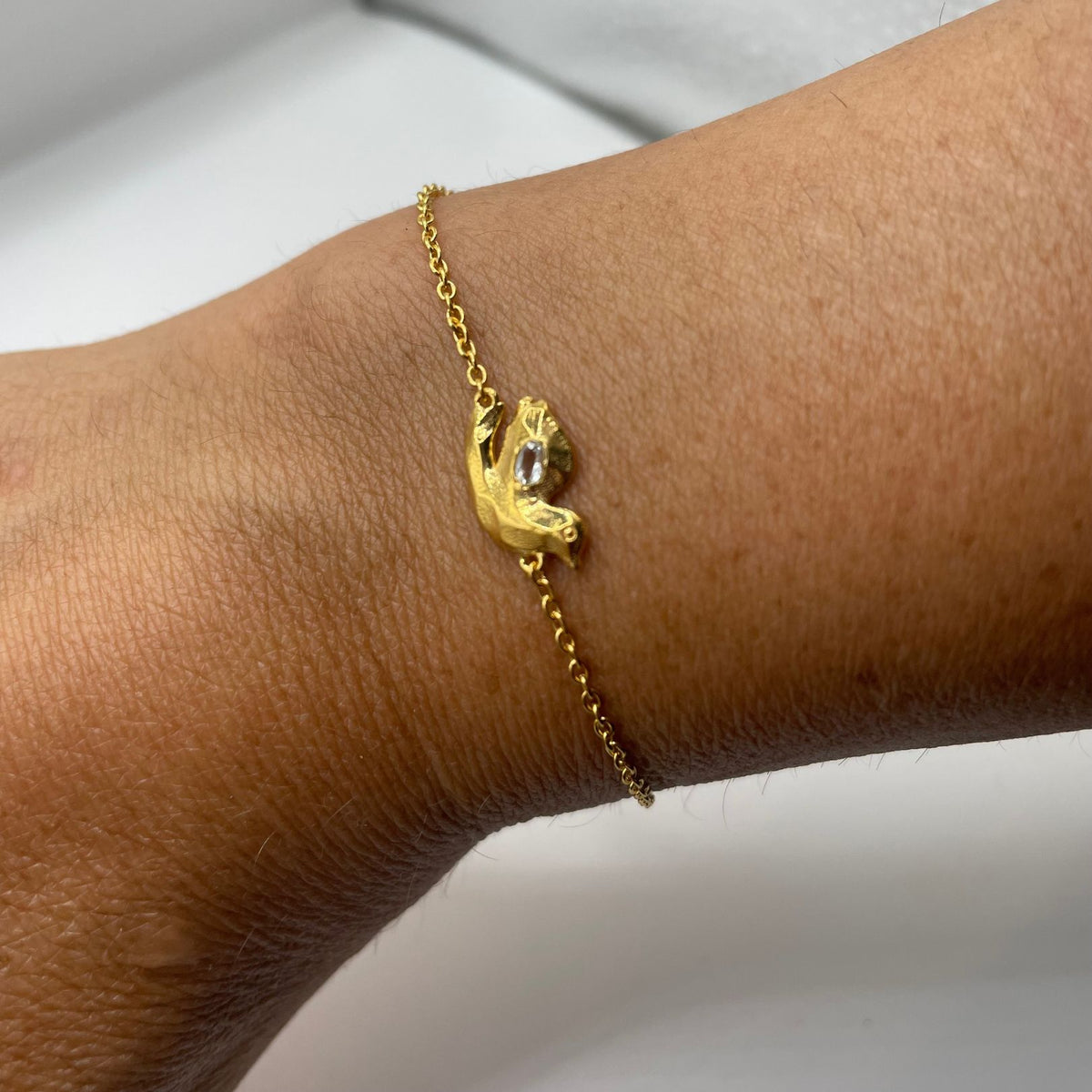 Gold white topaz dove bracelet by Amy Delson on wrist