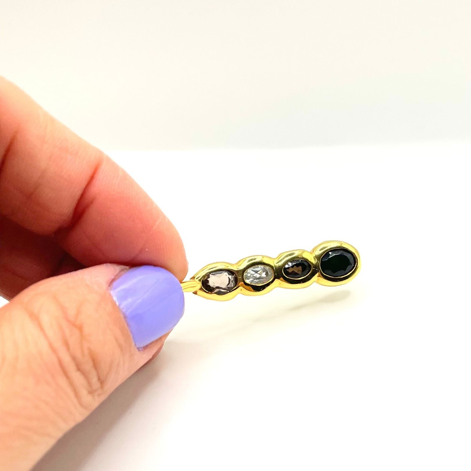 Hand holding Amy Delson Onyx White Topaz Smoky Quartz Olivia Pendant Necklace in Gold