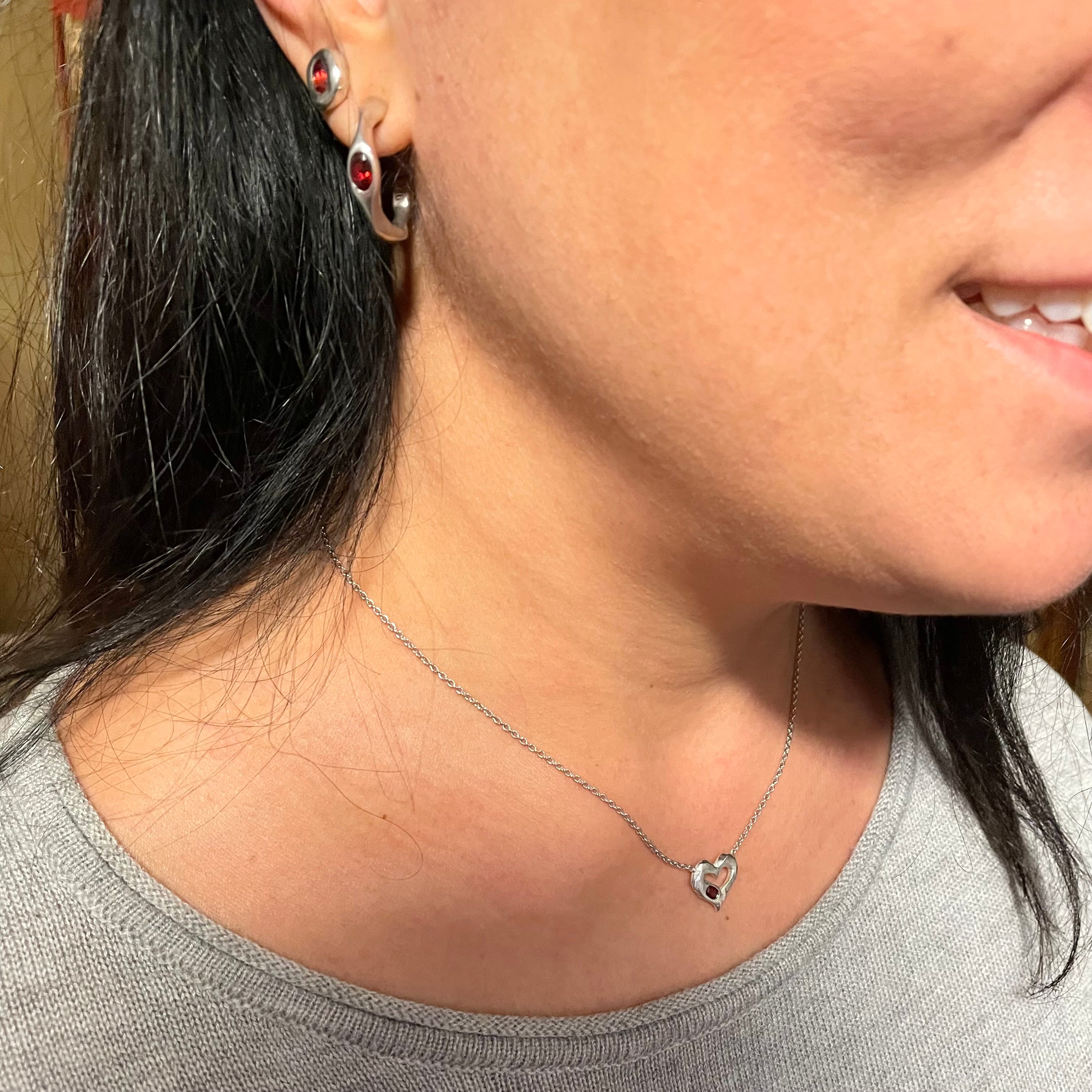 Model wears Garnet and Sterling Silver Earrings and Heart Necklace by Amy Delson