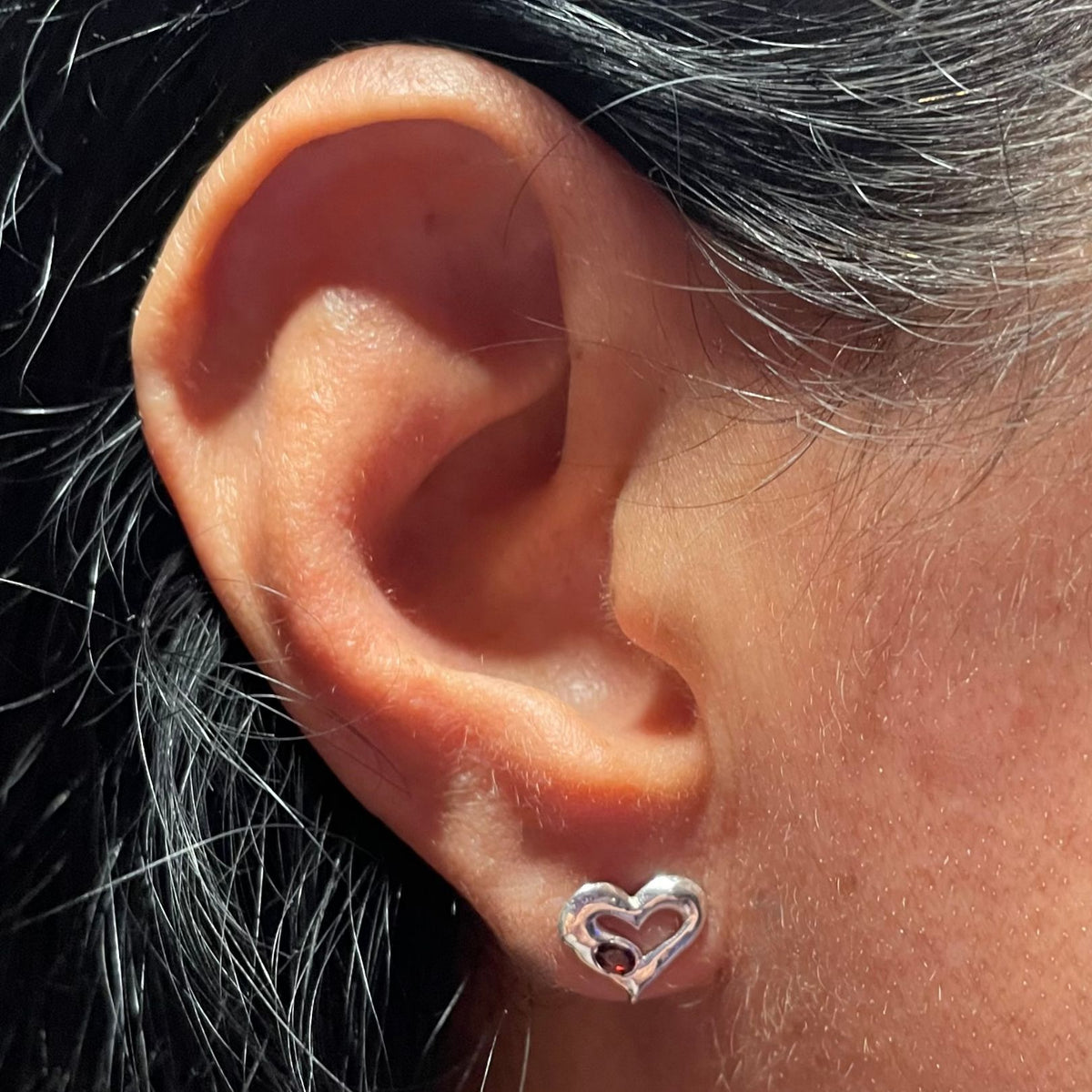 Silver garnet heart stud on ear by Amy Delson