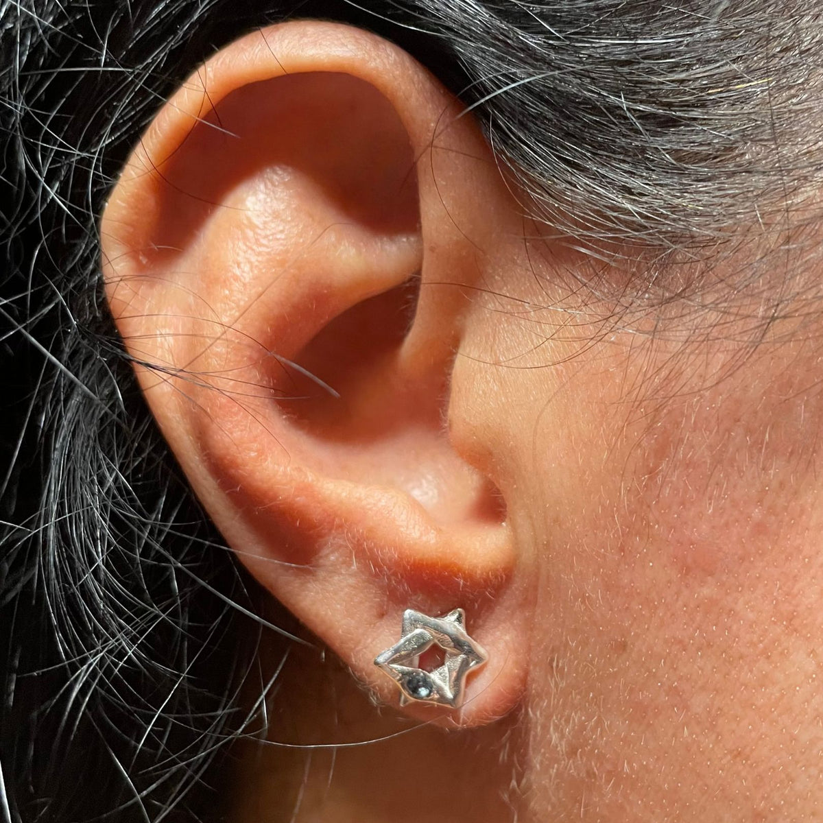 Silver blue topaz Star of David stud earring by Amy Delson shown on ear 