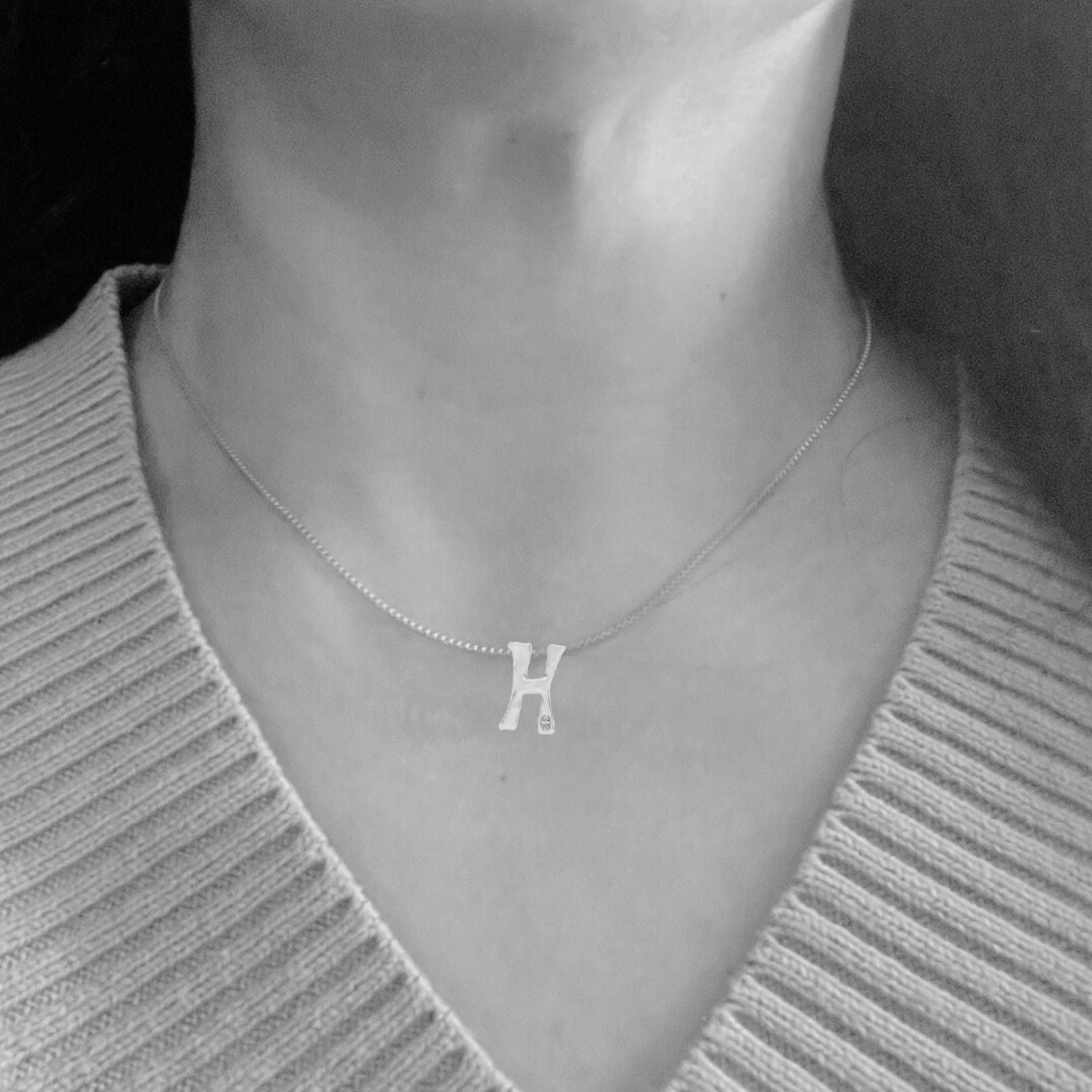 model wears white gold with lab diamond letter H necklace by Amy Delson