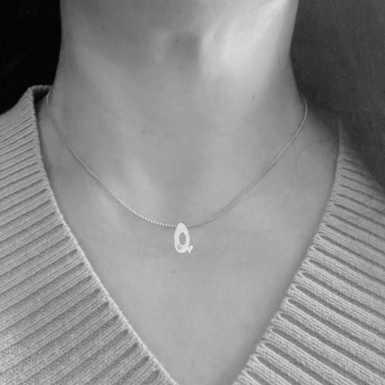 model wearing white gold with lab diamond letter Q necklace by Amy Delson