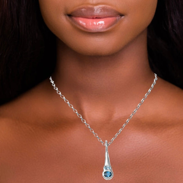 Silver pendant with blue topaz on model by Amy Delson