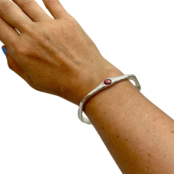 Amy Delson Garnet Sterling Silver bangle bracelet shown on wrist