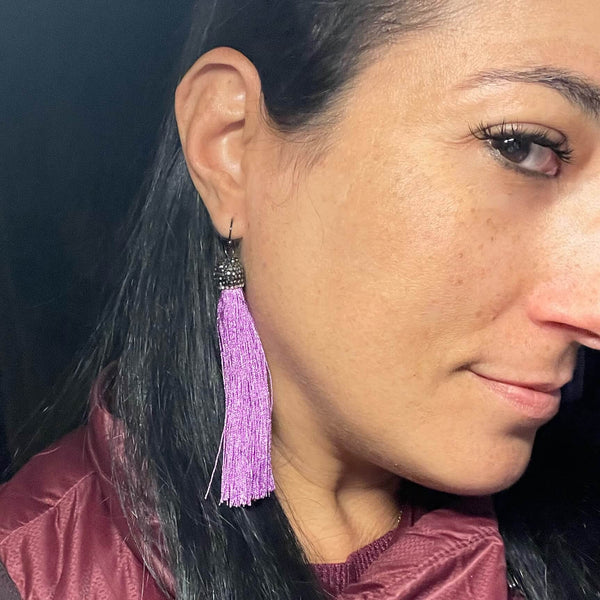 Amy Delson wearing purple tassel earring